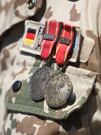Die Einsatzmedaillen der Bundeswehr Atalanta und UNIFIL in Bronze Zwei Einsatzmedaillen der Bundeswehr in Bronze sind an einem Feldanzug angesteckt