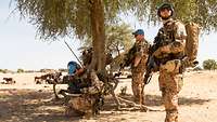 Soldaten auf Patrouille in Mali Soldaten mit blauen Mützen sind auf einer Patrouille. Im Hintergrund grasen Rinder.