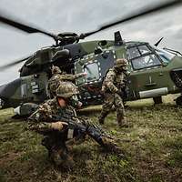 Soldaten tragen einen Verwundeten zu einem Hubschrauber NH-90.