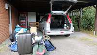 Neben dem leeren Kofferraum von Bickerts Auto stapelt sich das Gepäck.