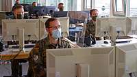 Soldaten sitzen vor Computern im Rahmen der Kontaktnachverfolgung