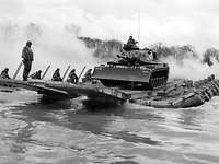 Ein Panzer wir auf einer Schlauchbootbrücke über eine Fluß transportiert. Schwarz-Weiß-Aufnahme: Ein Panzer auf einer Schlauchbootbrücke