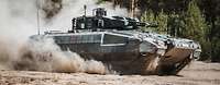 Schützenpanzer Puma sich auf dem Truppenübungsplatz Ein Schützenpanzer Puma fährt durch das Gelände und wirbelt Staub auf