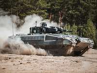 Schützenpanzer Puma sich auf dem Truppenübungsplatz Ein Schützenpanzer Puma fährt durch das Gelände und wirbelt Staub auf