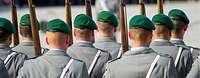 Feierliches Gelöbnis auf dem Paradeplatz des Bundesministeriums der Verteidigung in Berlin Mehrere Soldaten (von hinten gesehen) mit grünem Barett stehen mit ihren Gewehren in drei Reihen nebeneinander