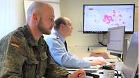 Two soldiers working at computers