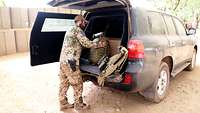 Robert belädt den Land Cruiser mit seiner Schutzweste und dem Sanitätsrucksack