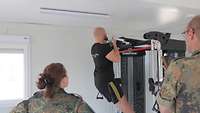 Ein Soldat hängt an einer Klimmzugstange, um den Basis Fitness Test zu bestehen.
