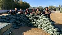 Gemeinsam gegen den Lärm Die Soldaten stehen hinter ihren selbst errichteten Lärmschutzwänden.