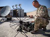 Satellitenkommunikation in Afghanistan Ein Soldat baut eine Antenne auf.