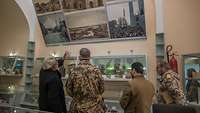 Der Imam führt die deutschen Soldaten durch das Museum der Moschee und erklärt ihnen verschiedene Exponate