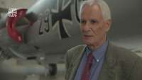 Älterer Herr vor einem Kampfflugzeug im Hangar