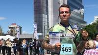 Ernst mit der Teilnahme-Urkunde und Teilnehmer-Medaille des Halbmarathons