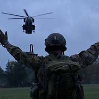 Ein Soldat weist einen Hubschrauber ein. 