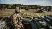 Amerikanischer Soldat sitzt auf einem militärischen Fahrzeug 