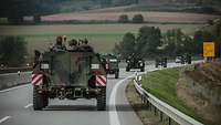 Militärische Fahrzeuge im Konvoi auf einer Straße