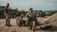 Deutscher Soldat und zwei US Soldaten vor den Fahrzeugen