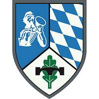 Im silbern-blau geteilten Wappen rechts ein Pionier, links ein Edelweiß, darüber eine Pionierbrücke.
