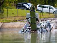 Ein Panzer fährt in ein Betonbecken welches mit Wasser gefüllt ist. Im Hintergrund stehen weitere Autos