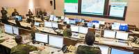 Ein Raum mit vielen Monitoren und Soldaten 