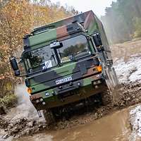 Ein LKW fährt durch ein Schlammloch.