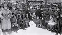 Gruppenfoto von Soldaten vor einer Holzhütte im Winter