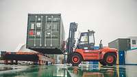 Ein Stapler verlädt einen Militärcontainer am Rostocker Hafen auf ein Schiff.