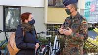 Ein Soldat unterhält sich mit einer Zivilistin