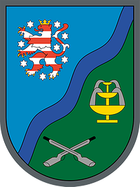 Wappen des Panzergrenadierbataillons 391 Thüringens Löwe auf blauem Grund, Gewehre und Solebrunnen auf grünem Grund, mittig der Fluss Werra