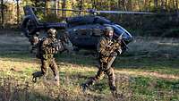 Soldaten laufen zu den am Boden wartenden Hubschraubern.