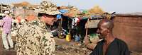 Ein deutscher Soldat schüttelt einem Einheimischen in Bamako die Hand.