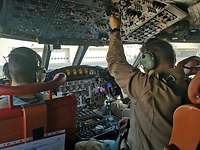 Zwei Männer sitzen angeschnallt im Cockpit und schauen auf die Instrumente