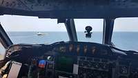P-3C im Tiefflug über dem Wasser und nähert sich einem Schiff