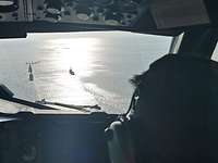 Blick aus dem Cockpit auf eine vorrausfliegende P-3C und Kriegsschiffe