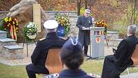 Ein Soldat steht an einem Pult und hält eine Rede 