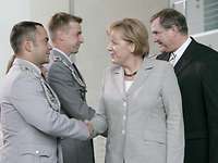 Angela Merkel und Jung gratulieren den beiden Soldaten