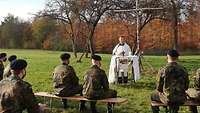 Militärpfarrer Michael Bendel und Soldaten beim Freiluft-Gottesdienst unter dem Birkenkreuz