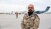 Ein Soldat steht auf dem Airfield, im Hintergrund stehen Flugzeuge