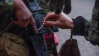 Zwei Soldaten reinigen das Rohr des G36