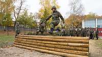 Soldat springt im Rahmen seiner Grundausbbildung über ein Hindernis.