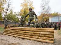 Soldat springt im Rahmen seiner Grundausbbildung über ein Hindernis.