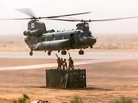 Soldaten hängen eine Außenlast an einen kanadischen Transporthubschrauber Chinook.