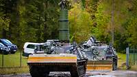 Dachs armored engineer vehicle with turret at WTD 52 A tank with a large tube attached to its top. A soldier is standing inside the tube.