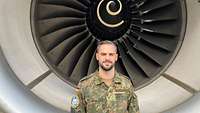 Hauptmann Benedikt U#de. steht vor dem Triebwerk des Airbus A330.