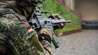 Ein Soldat hat das Gewehr im Anschlag und zielt.