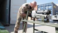 Ein Soldat schraubt an der Bordkanone