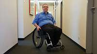 Mann im Rollstuhl im Flur