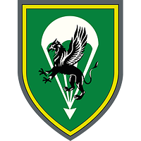 Das grüne Wappen ist golden umrandet, darauf ein silberner Fallschirm mit stilisiertem Greif.