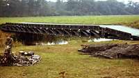 Eine Kriegsbrücke verbindet die zwei Ufer eines Flusses.