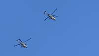 Zwei Bordhubschrauber in der Luft. Sie befinden sich im Sinkflug